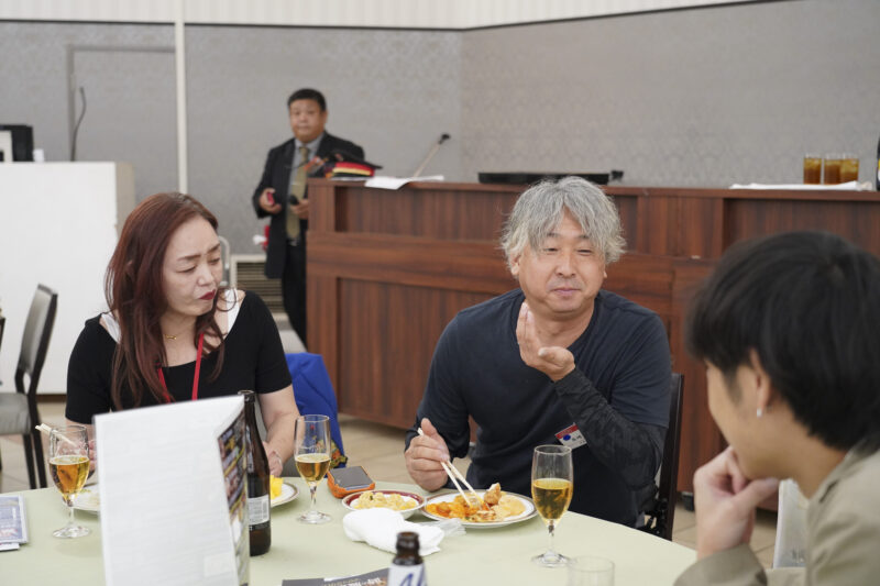 料理を囲みながら会話する事業者のグループ