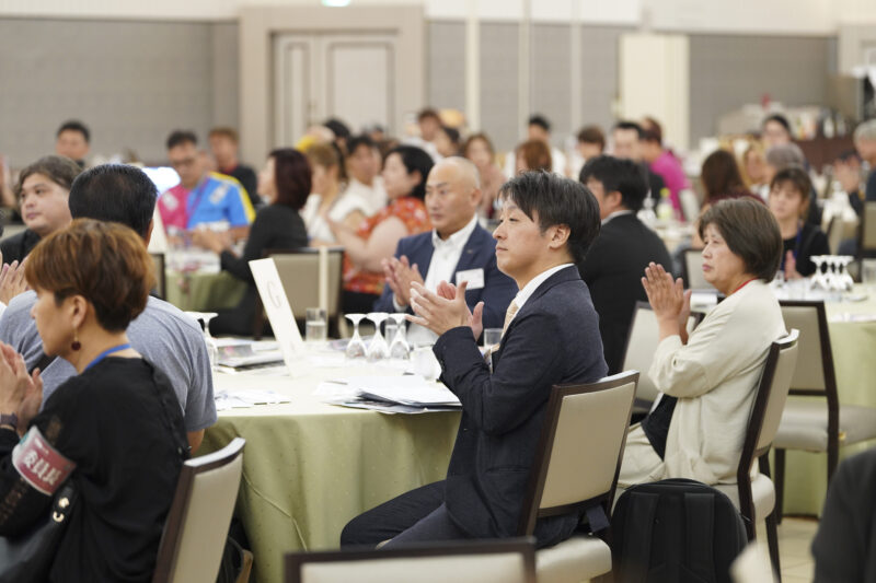 守成クラブ佐賀の会場で拍手する参加者たち