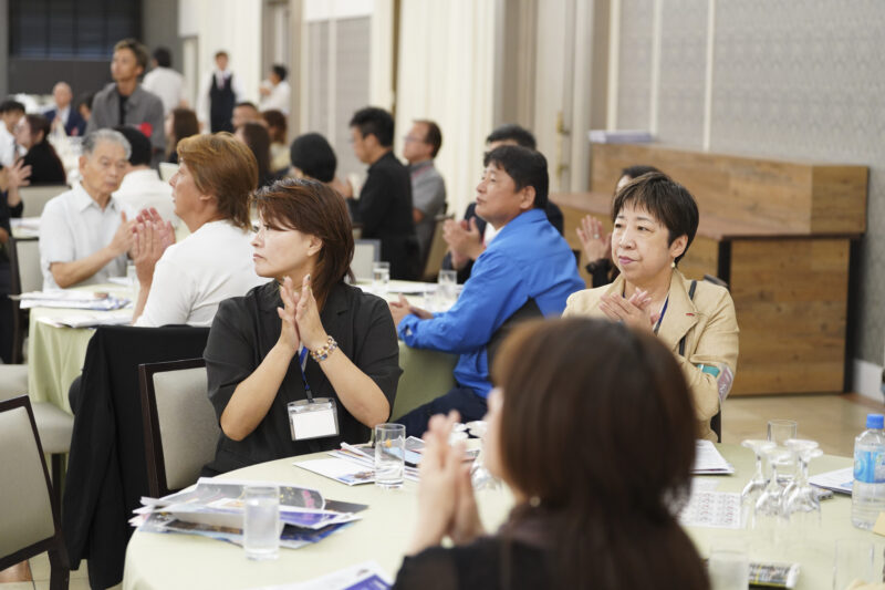 定例会で拍手を送る参加者の様子