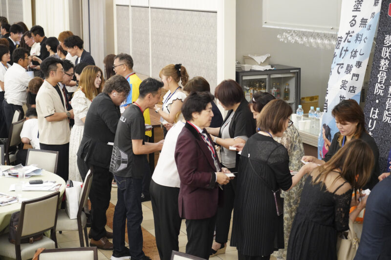 会場内で事業者同士が名刺を手に交流する様子